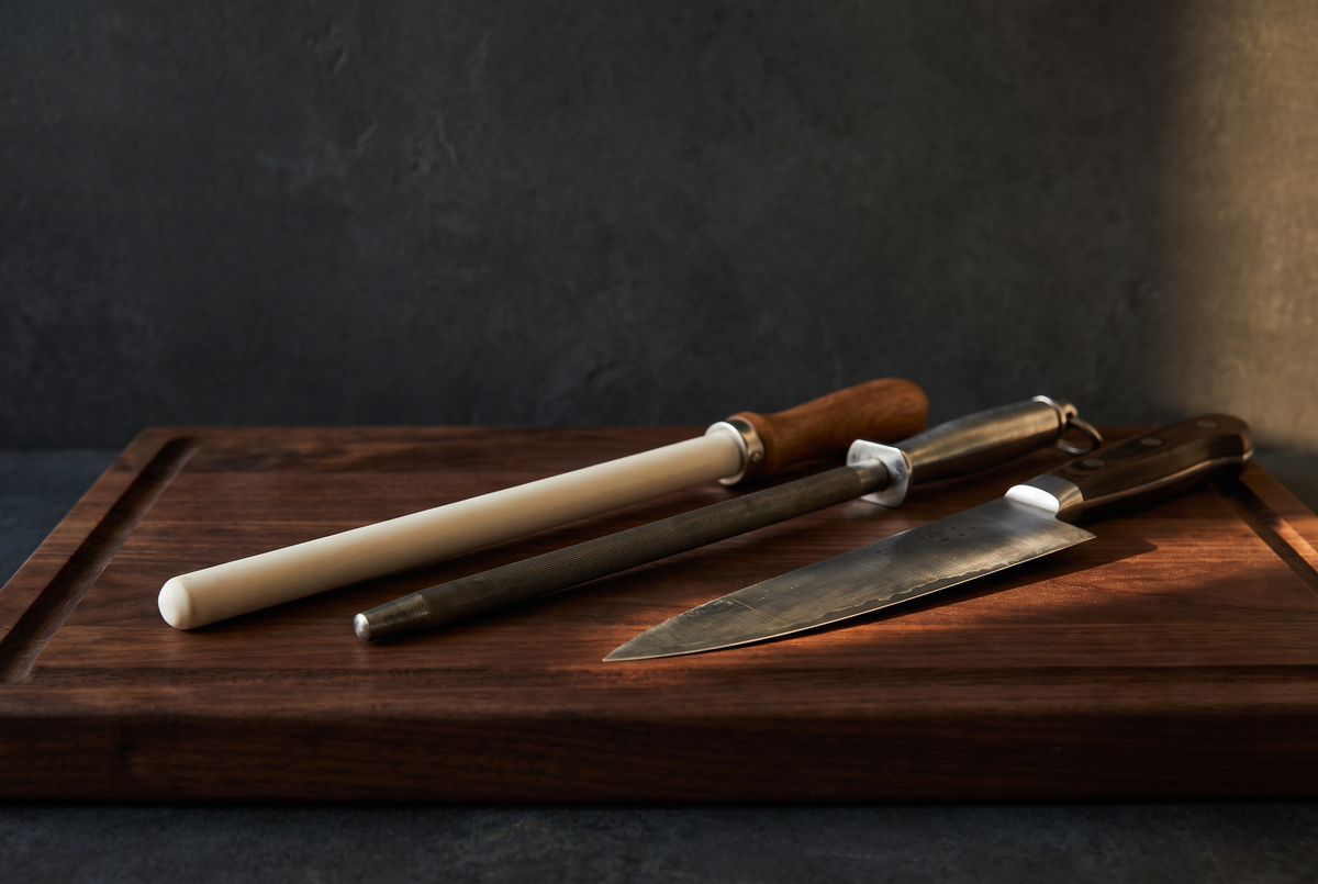 Ceramic honing rod, steel rod and chef knife on a walnut board